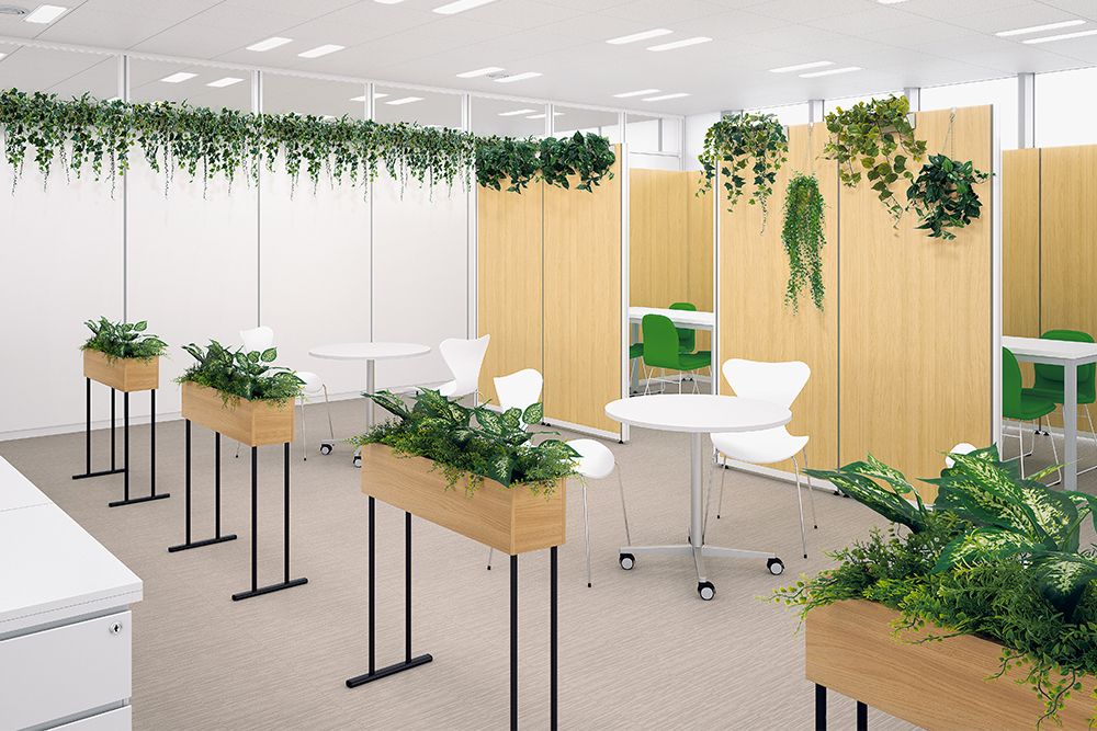 オフィスのワークスペースと休憩スペースをさりげなく仕切るグリーンパーテーション。